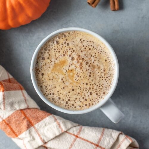 A close up of a pumpkin spice latte on a grey background