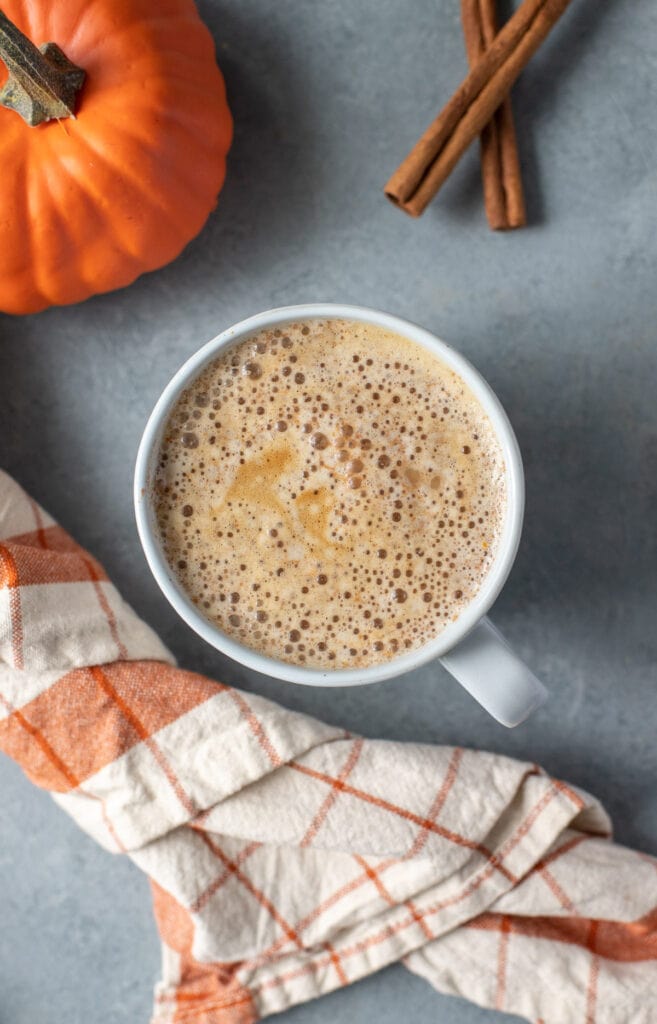 A close up of a pumpkin spice latte on a grey background