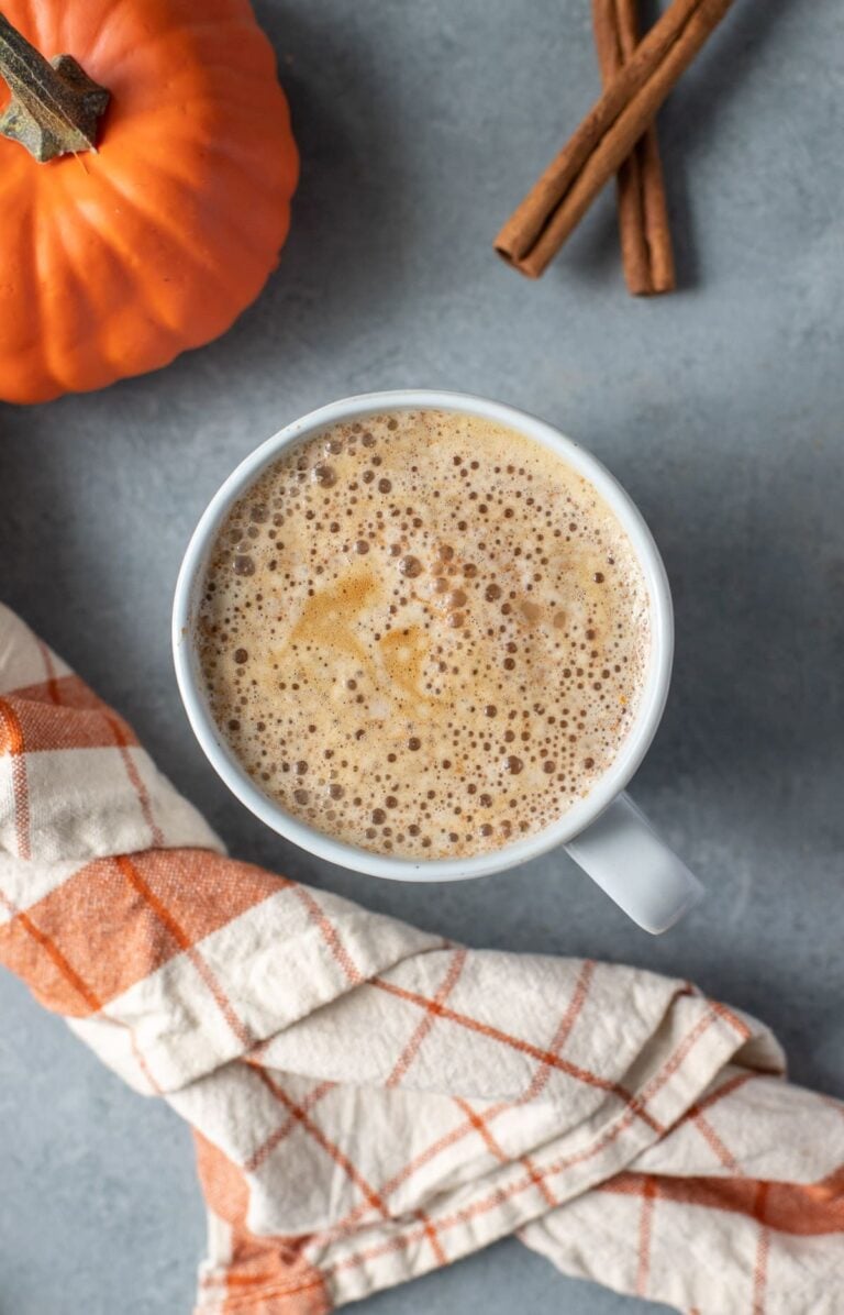 A close up of a pumpkin spice latte on a grey background