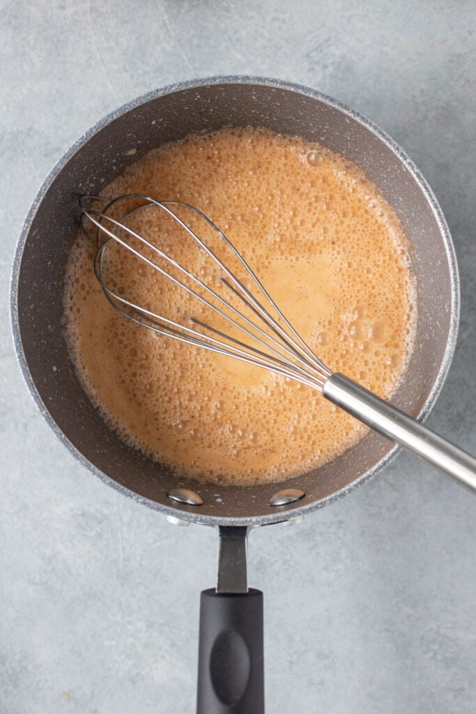 a easy vegan pumpkin spice latte being heated up/whisked together on the stove