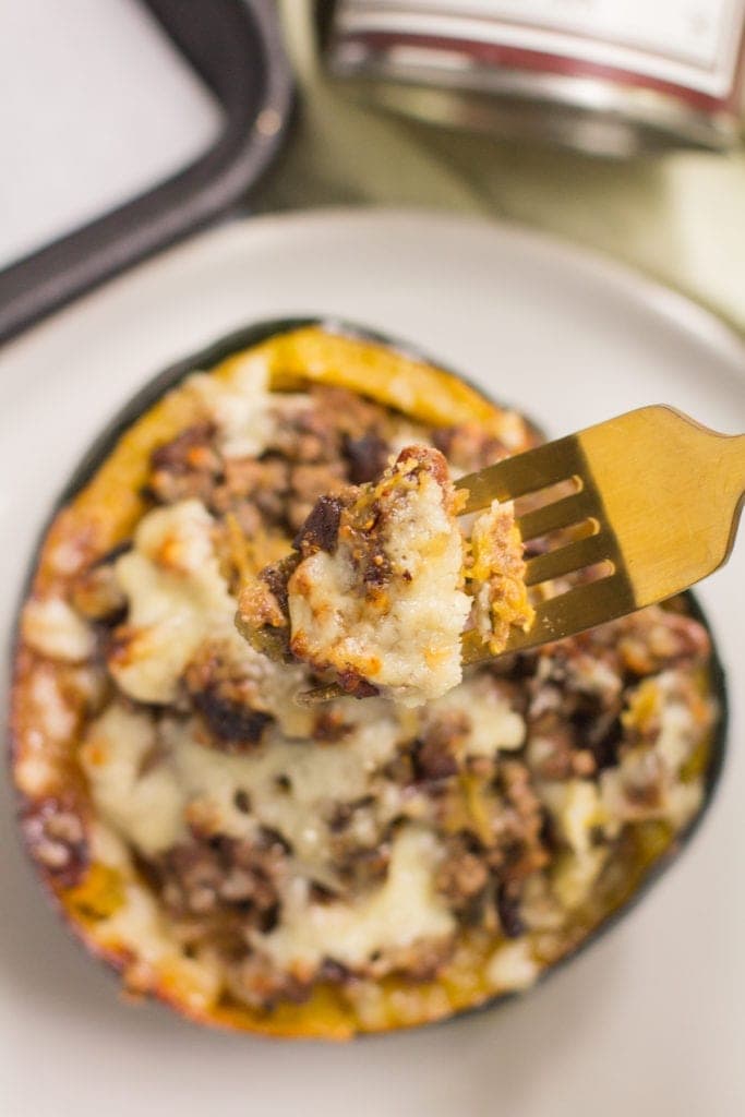 Easy gluten free stuffed acorn squash with a fork taking a bite out of it.