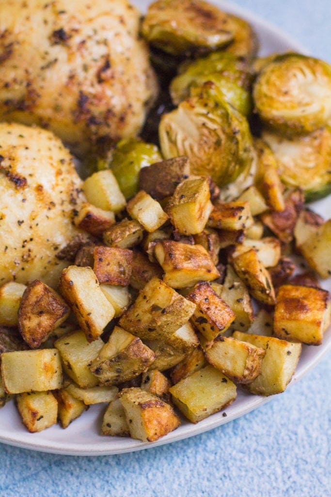 Crispy Dijon Roasted Potatoes on a plate with chicken thighs and brussels sprouts