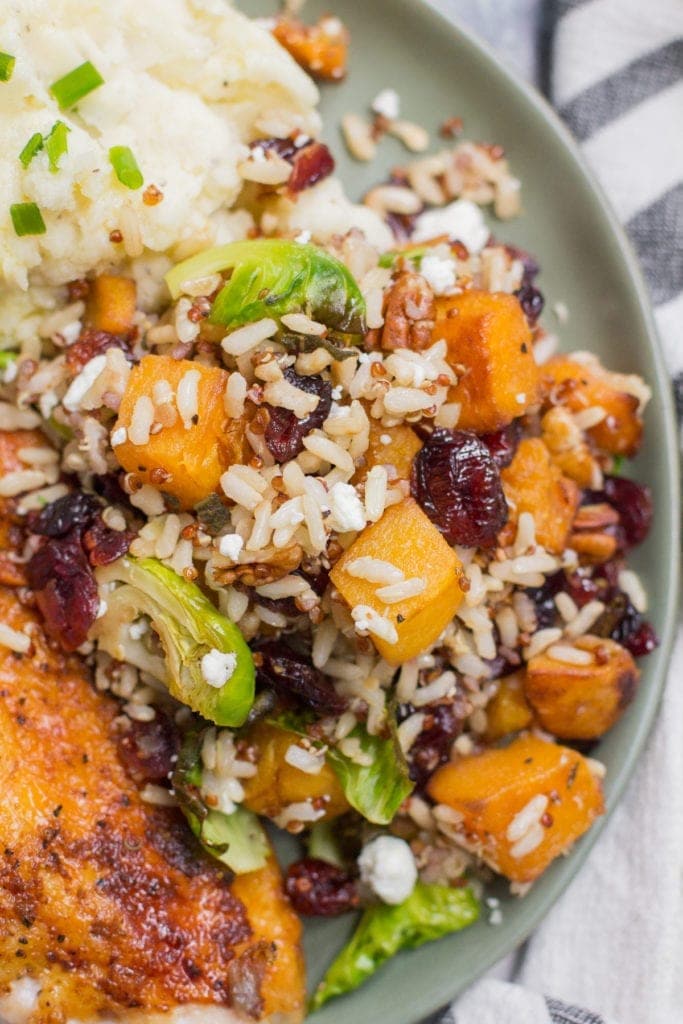 Harvest Quinoa Brown Rice Salad on a green plate with turkey and mashed potatoes for a holiday side.