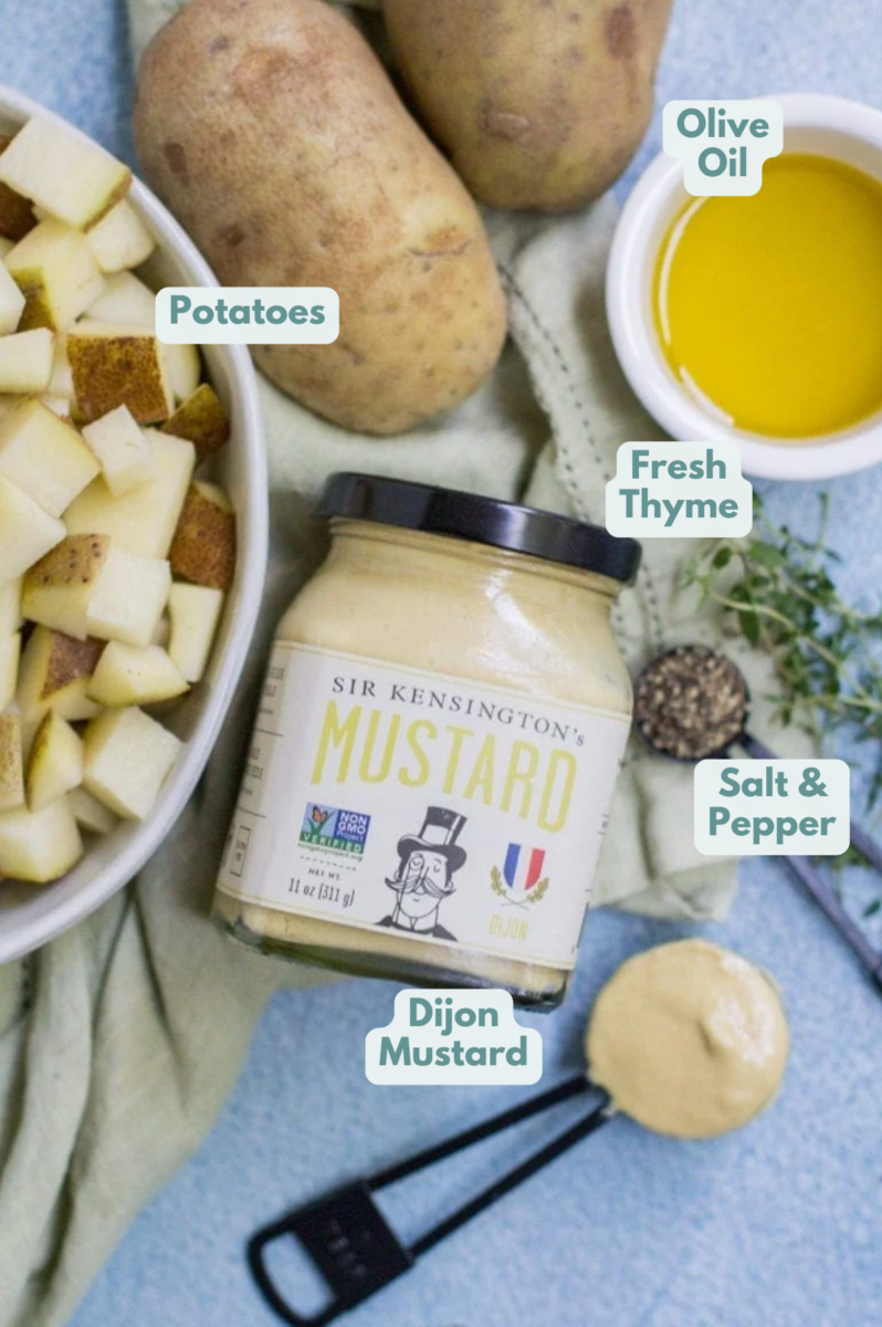 Ingredients for Crispy Dijon Roasted Potatoes. A white bowl with potatoes, Sir Kensington's mustard, olive oil, pepper, thyme.