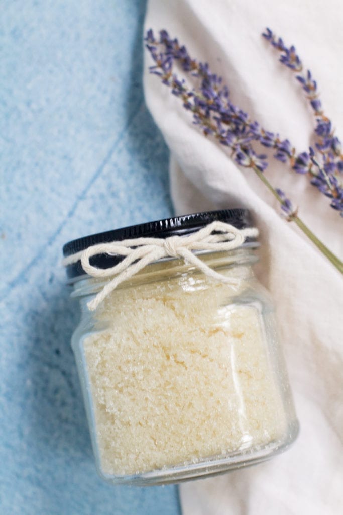 Easy DIY Sugar Scrub with a ribbon tied around it with lavender behind it.
