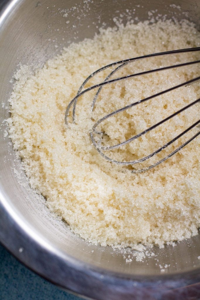 Easy DIY Sugar Scrub being whisked together in a stainless steel bowl
