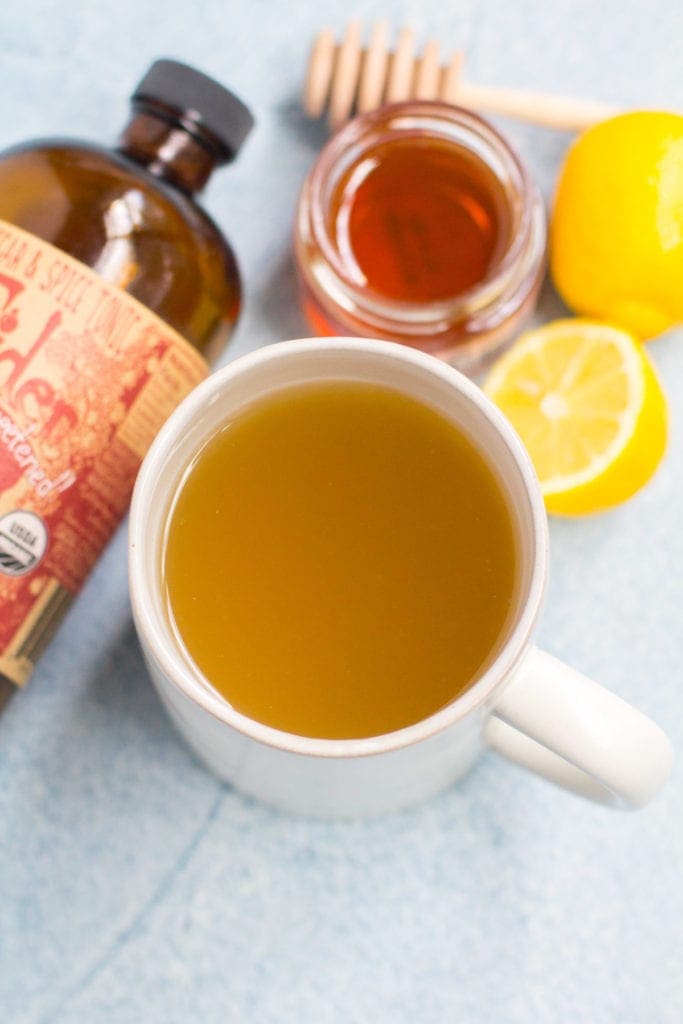 Home Remedy for Cough - Fire Cider Drink. A White mug filled with lemon, honey and fire cider