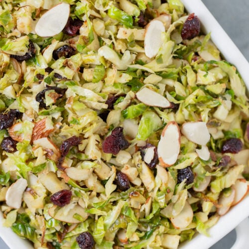 Shaved Brussels Sprouts Salad in a white dish on a grey background