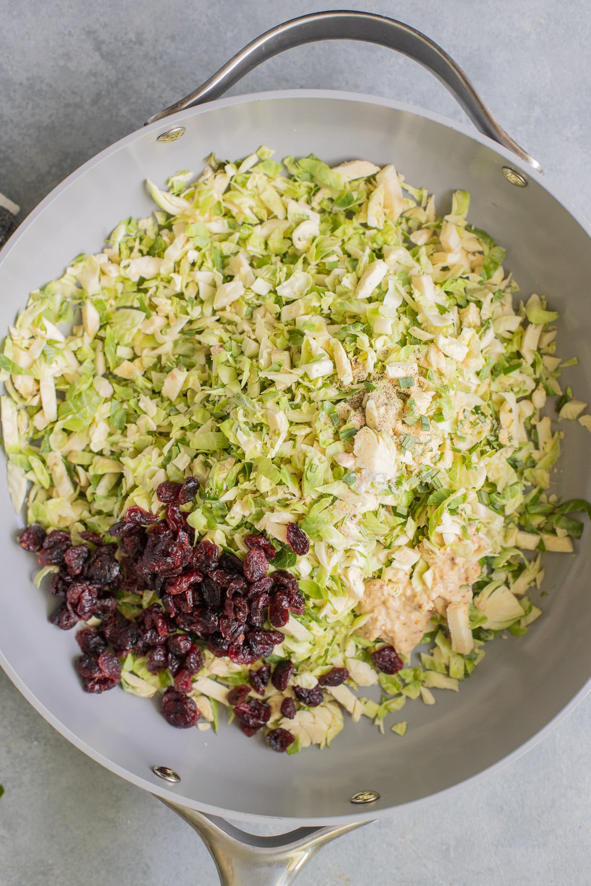 brussels sprouts in a pan after sauteing for shaved brussel sprout salad with other ingredients added in before mixing