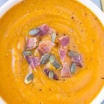 Healthy Butternut Squash Soup in a white bowl on a grey background.
