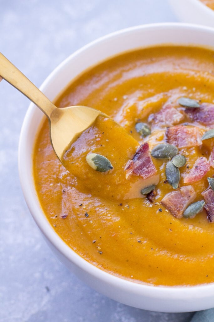 A spoon taking out a scoop of healthy butternut squash soup