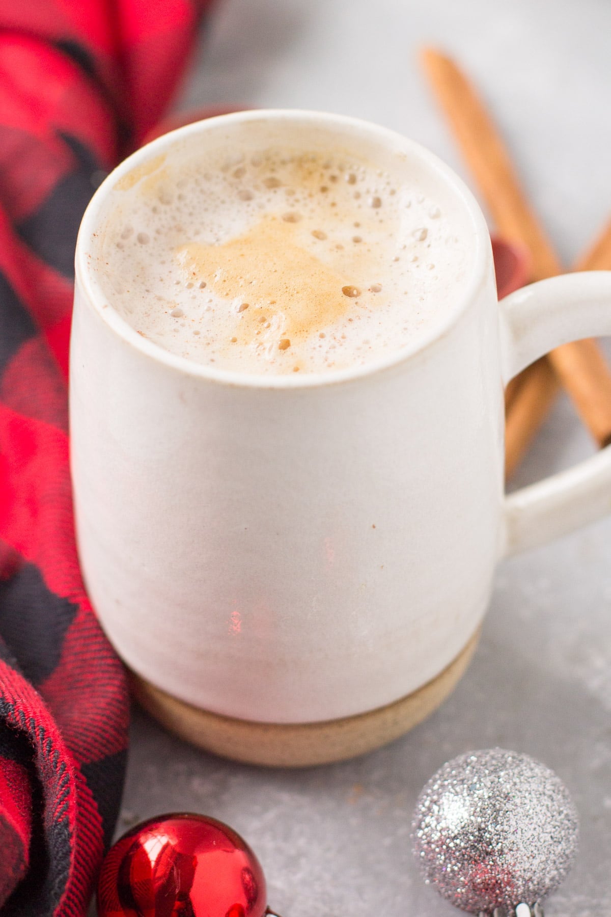 A cup of healthy gingerbread latte on a grey background in a white mug