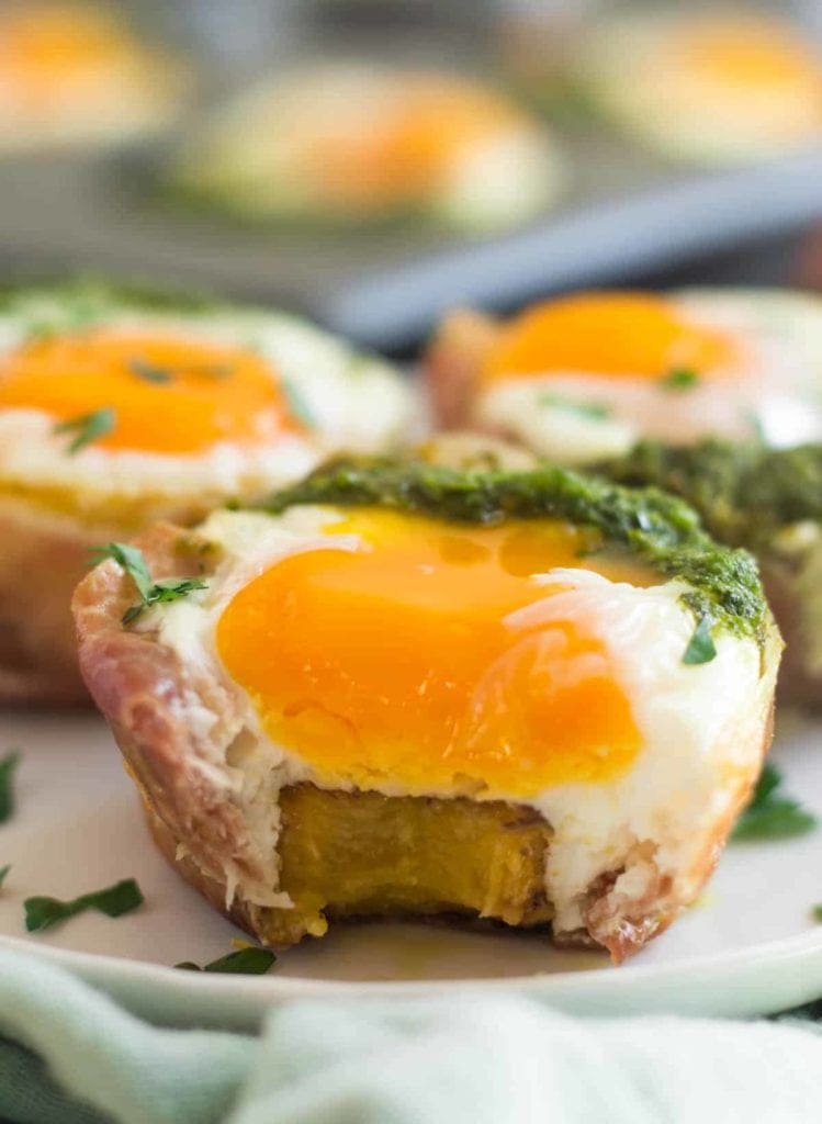 Prosciutto plantain whole30 egg cups on a white plate.