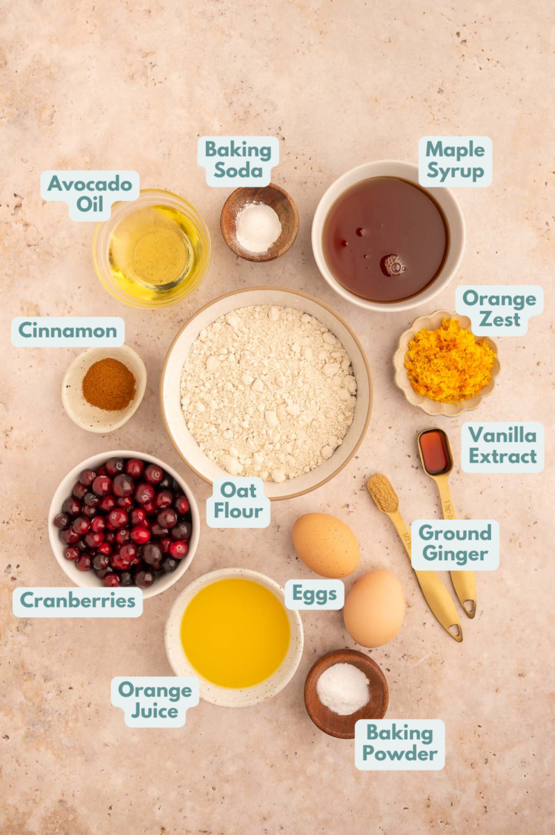 Labeled Healthy Cranberry Orange Muffin Ingredients in bowls and measuring cups on a counter.