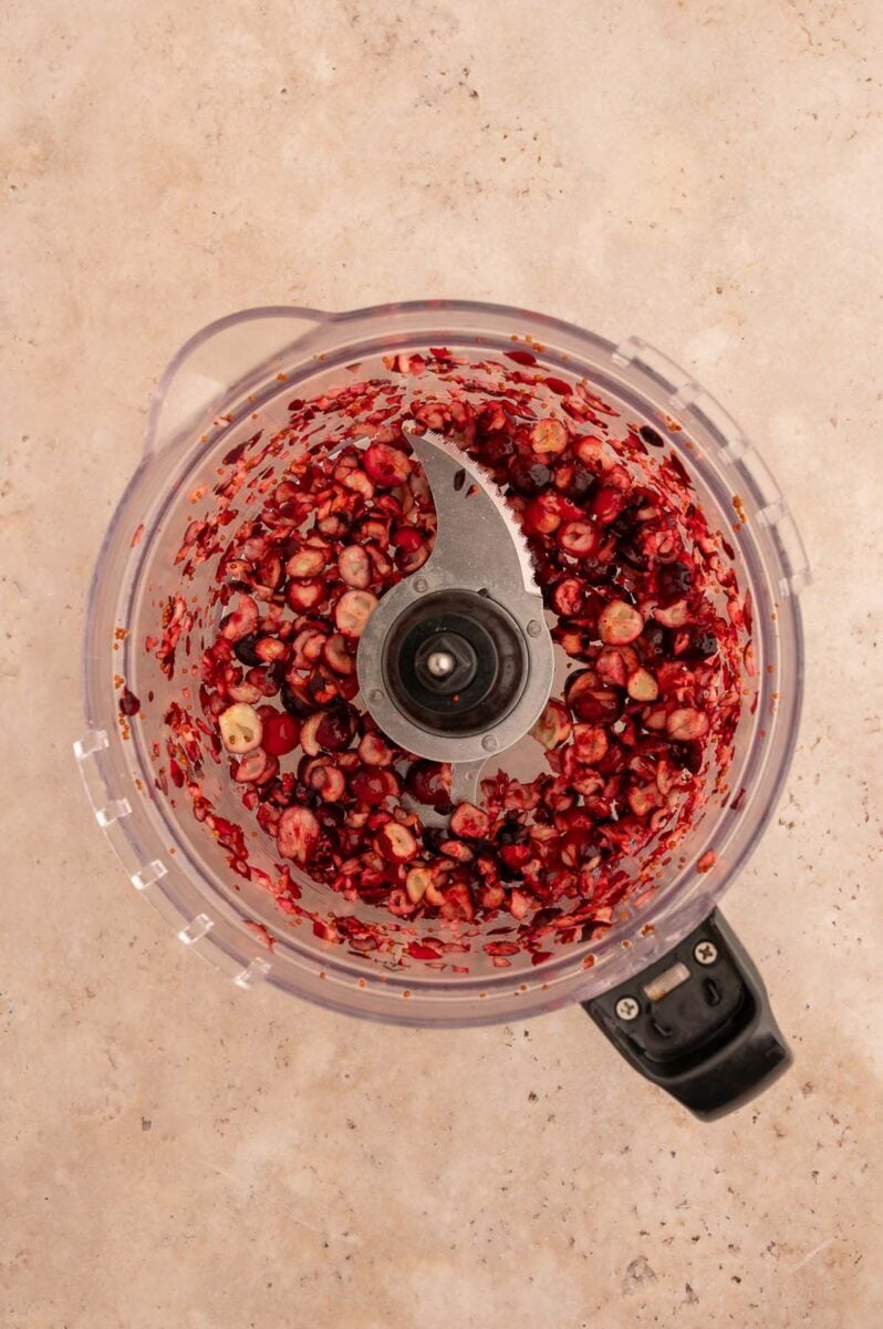Cranberry pieces in a food processor after being processed.