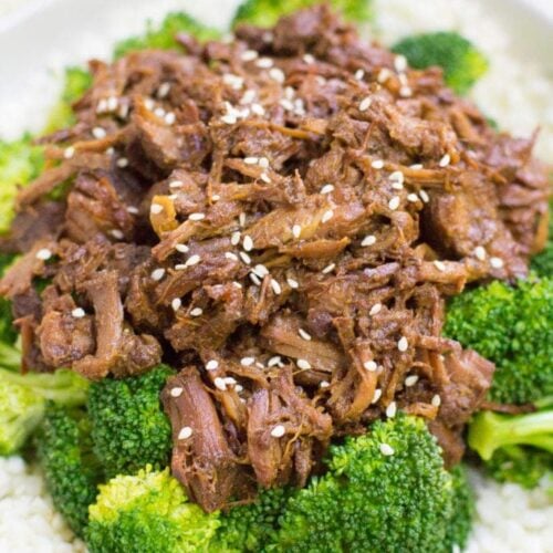Healthy Slow Cooker Beef + Broccoli over cauliflower rice in a white bowl.
