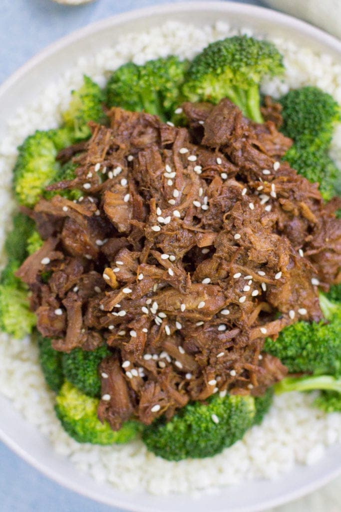 a big bowl of cauliflower rice topped with healthy slow cooker beef and broccoli.