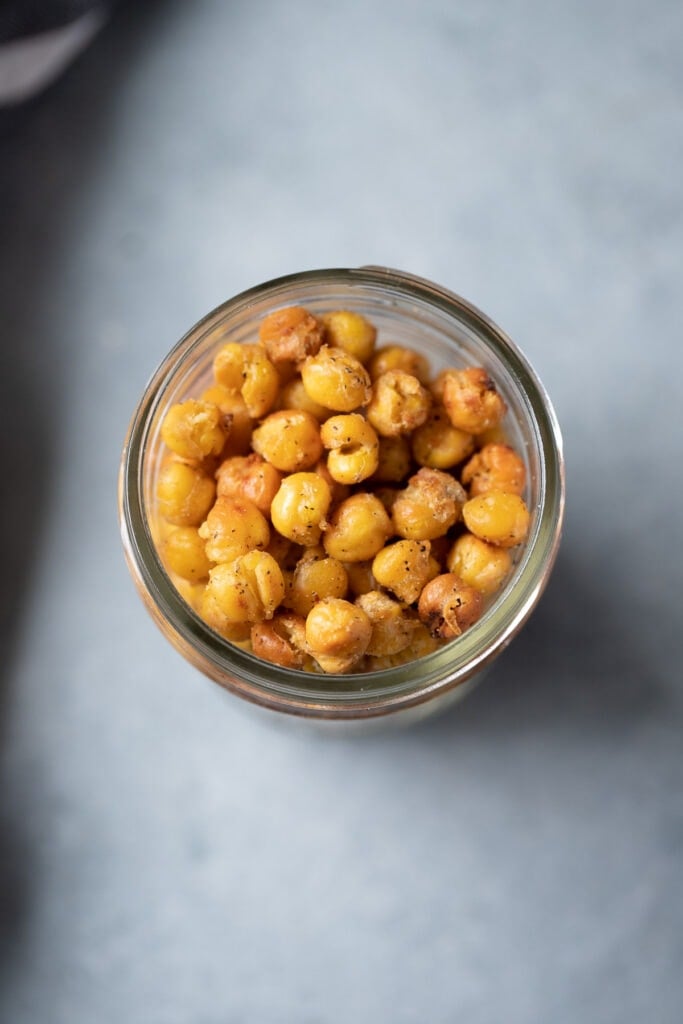 Healthy Roasted Chickpeas in a glass jar on a grey background