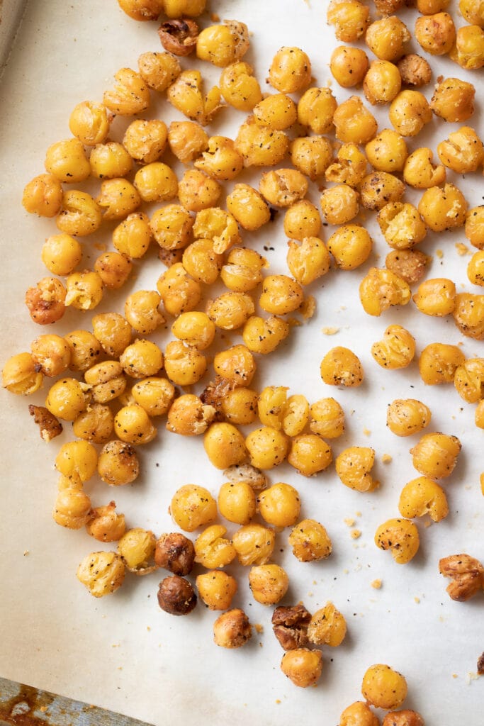 A baking sheet lined with parchment paper and covered in crunchy roasted chickpeas