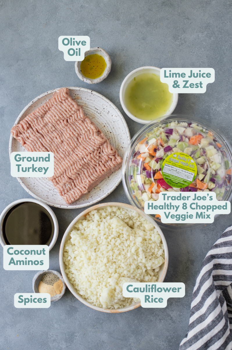 Ingredients for ground turkey skillet dinner in white bowls: olive oil, ground turkey, lime zest/juice, Trader Joe’s Healthy 8 Chopped Veggie Mix, garlic powder, pepper, onion powder, coconut aminos, regular rice, sesame seeds (optional)