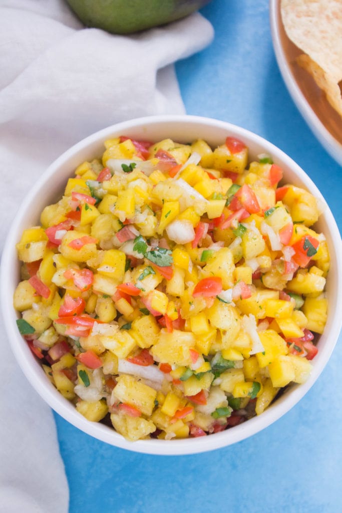 Fresh pineapple mango salsa in a large white bowl, viewed from overhead. 