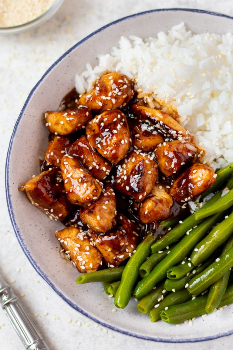 a grey plate with delicious healthy sesame chicken, white rice + green beans