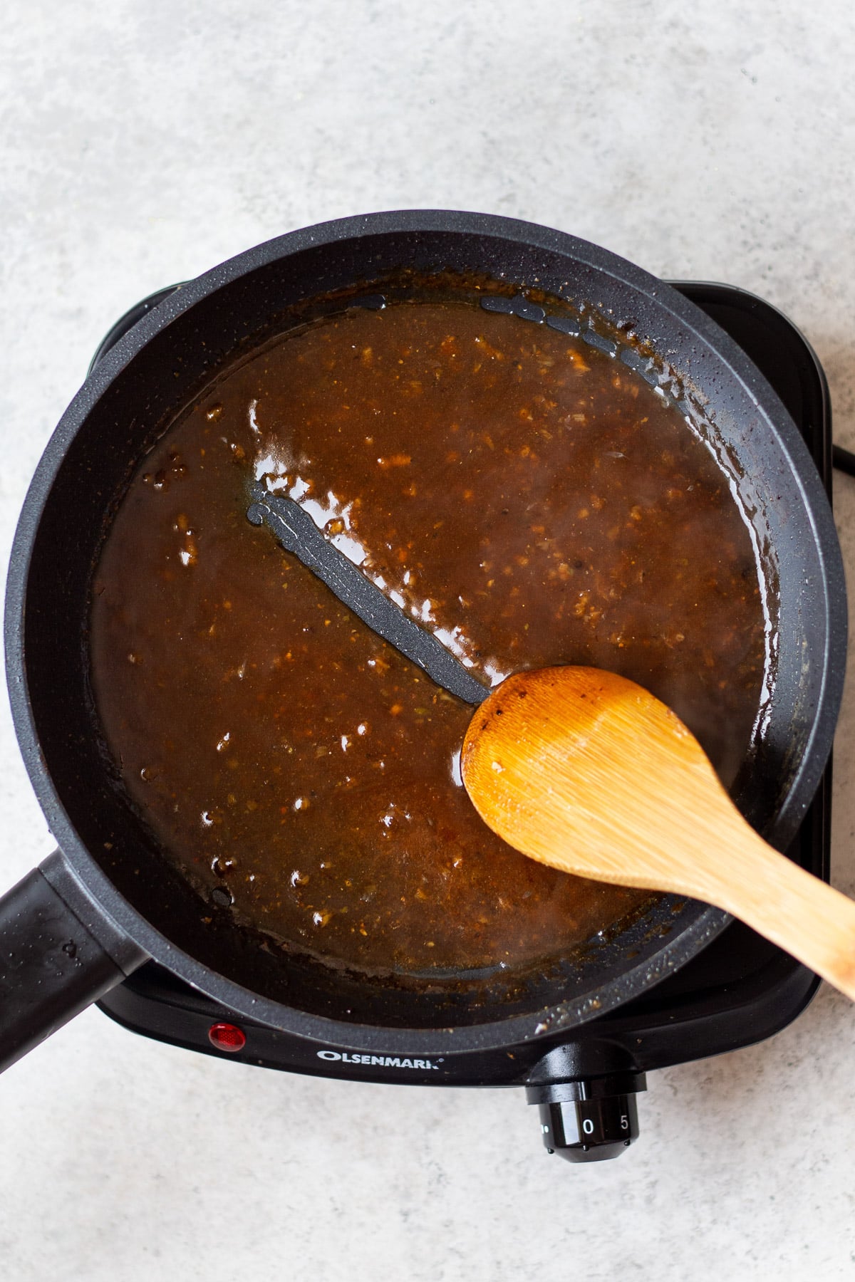 sauce for healthy sesame chicken cooking until thick in a cast iron pan