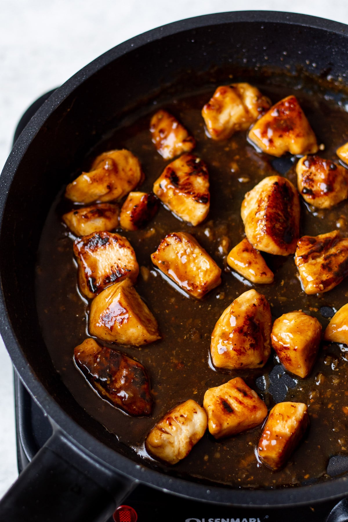 healthy sesame chicken in a cast iron pan