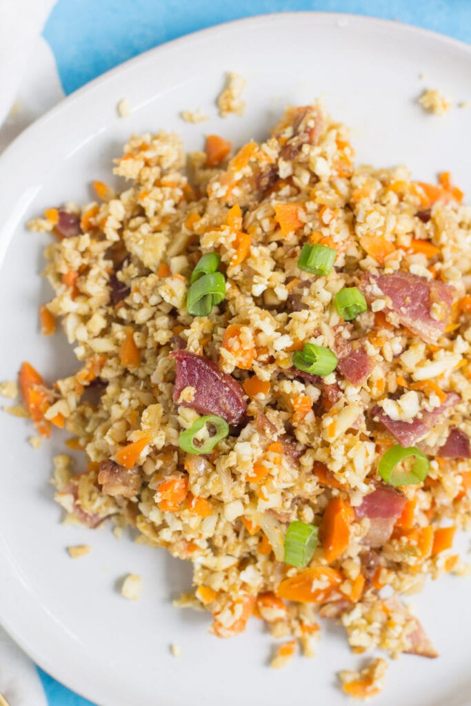 A white plate with breakfast cauliflower fried rice
