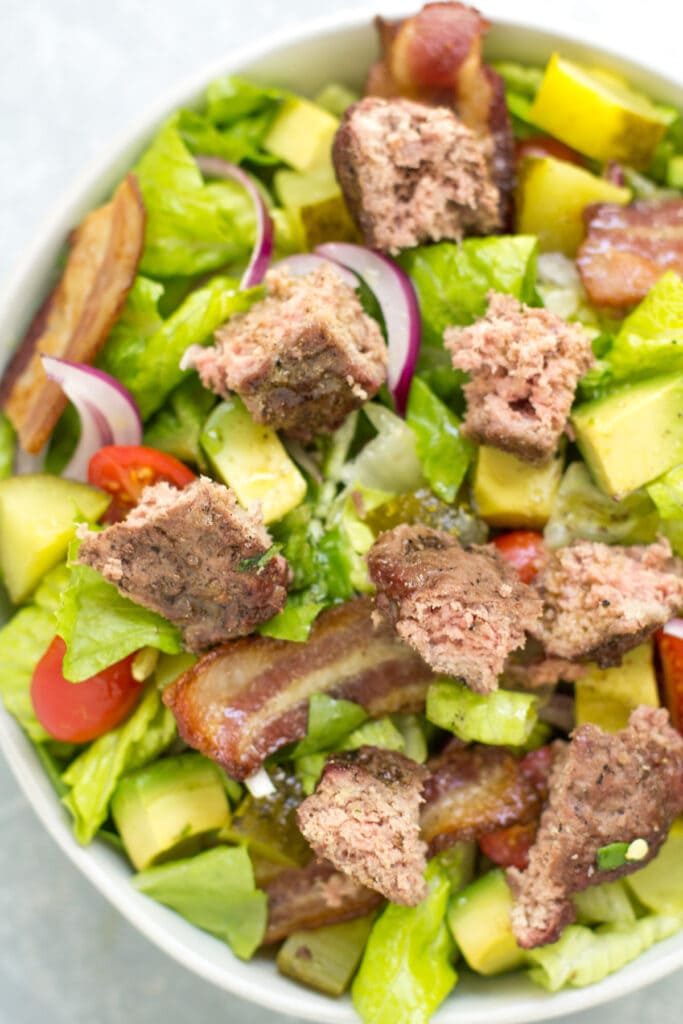 A bowl filled with a chopped up low carb burger salad