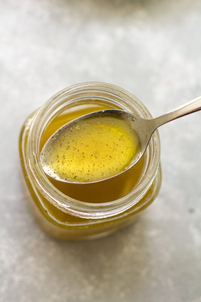 A close up of dill pickle vinaigrette in a glass jar