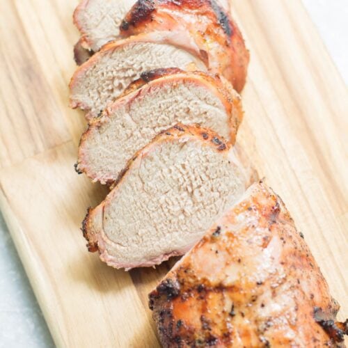 Grilled pork tenderloin on a wooden cutting board