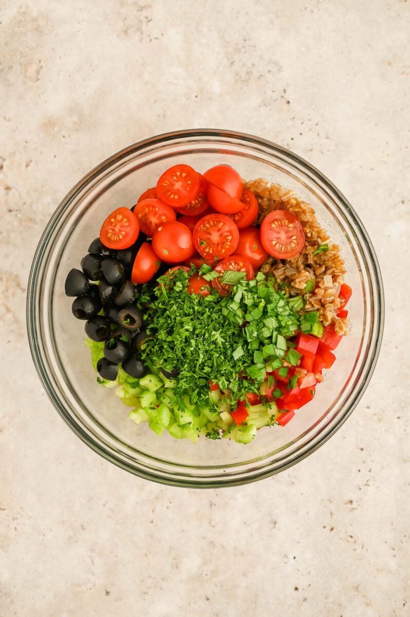 Ingredients for Easy Farro Salad in a clear bowl. 