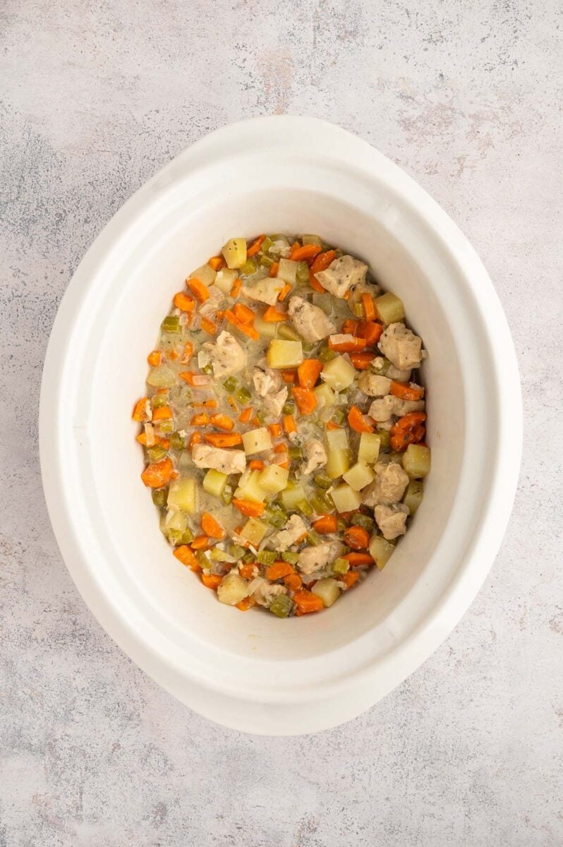 A crockpot of chicken stew after cooking and being mixed