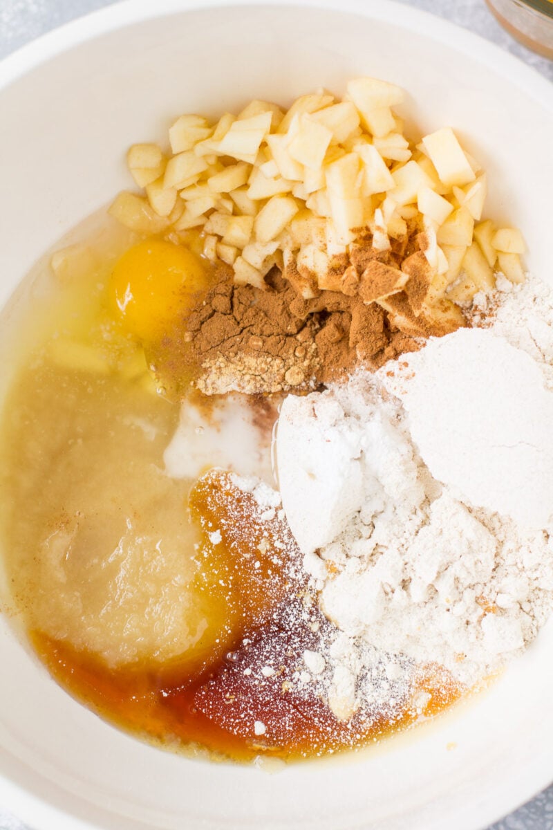 Ingredients for apple cider bread in a white bowl before being mixed
