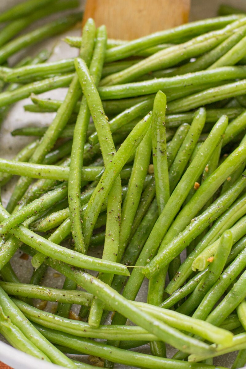 Green beans and spices cooking in a pan.