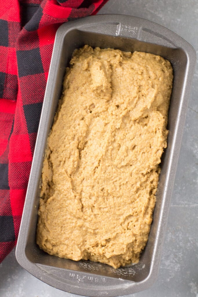 An overhead image of a healthy gingerbread loaf on a grey background