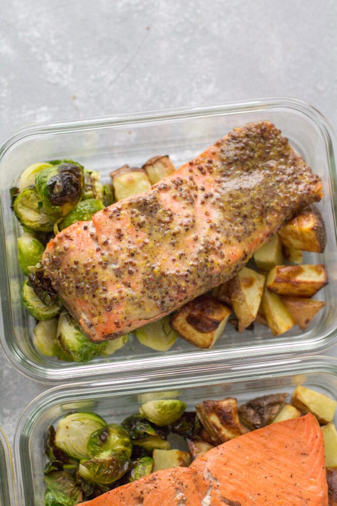 Healthy baked salmon in a glass container on a grey background