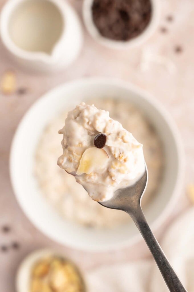 A spoon taking a bite out of almond joy overnight oats.