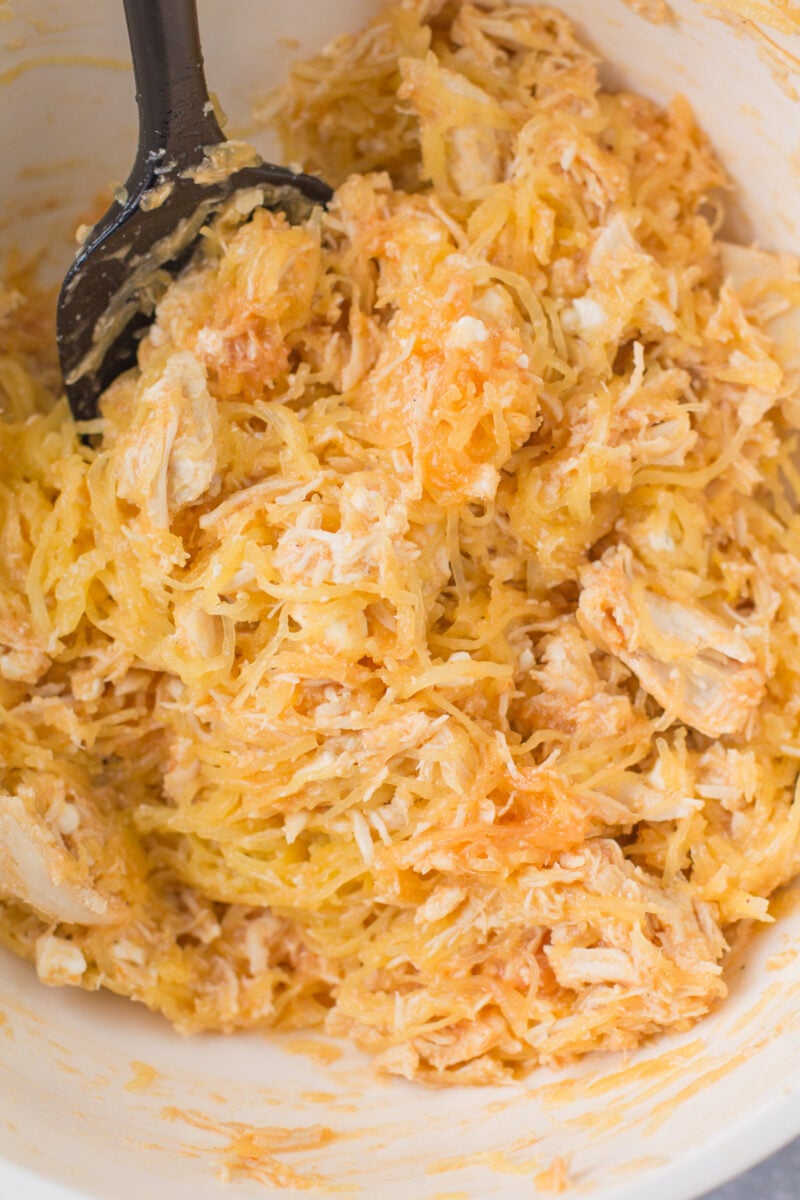 Ingredients for Buffalo Chicken Spaghetti Squash Casserole being mixed together in a bowl.