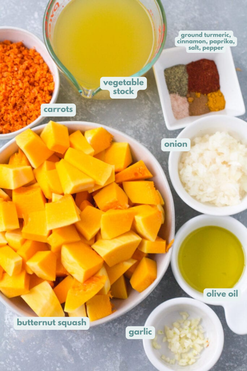 A top down shot of ingredients for Healthy Butternut Squash Soup. veggies, spices and broth are in small white bowls on a grey background.