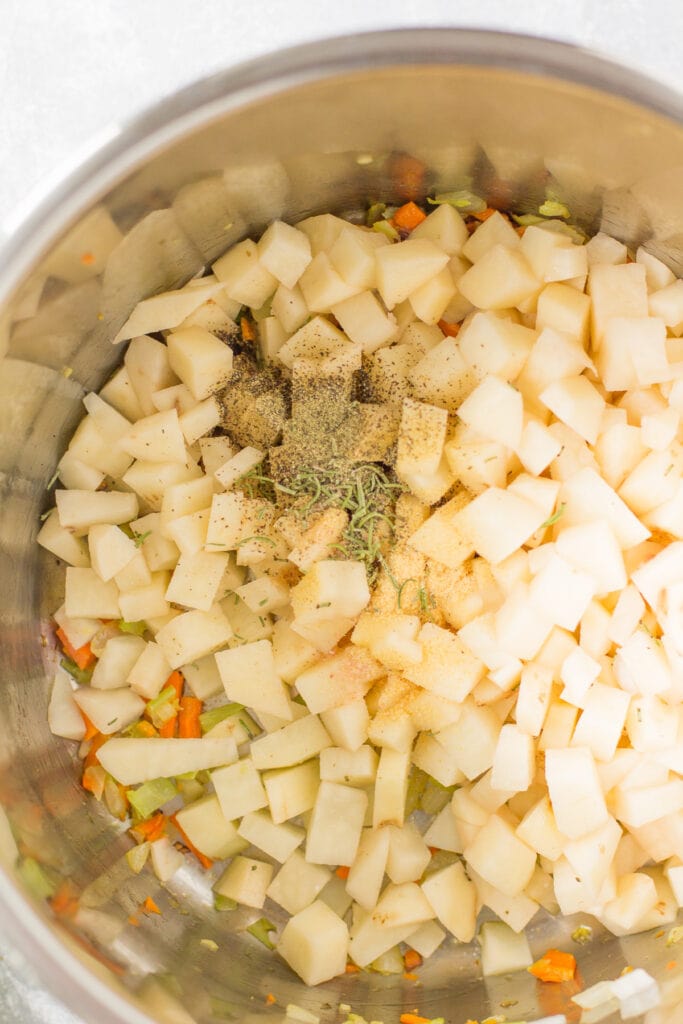 A close up of healthy potato soup in a pot before it is cooked