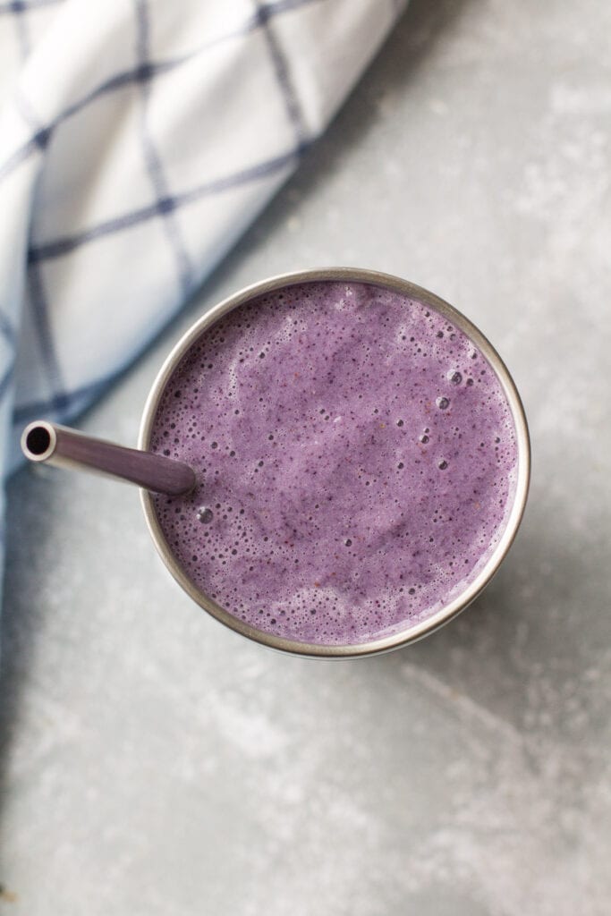 A close up of a berry smoothie box smoothie in a metal cup