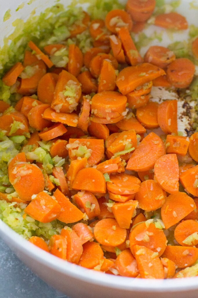 a close up of veggies sautéing in a pot on the stove