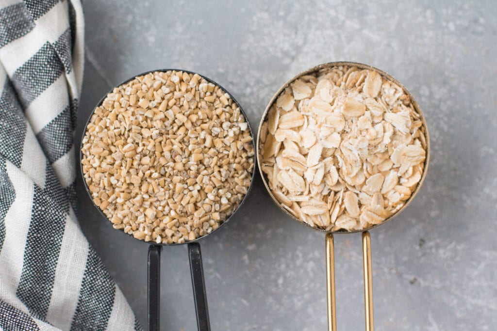 Two measuring cups showing the difference between steel cut oatmeal and old fashioned oatmeal