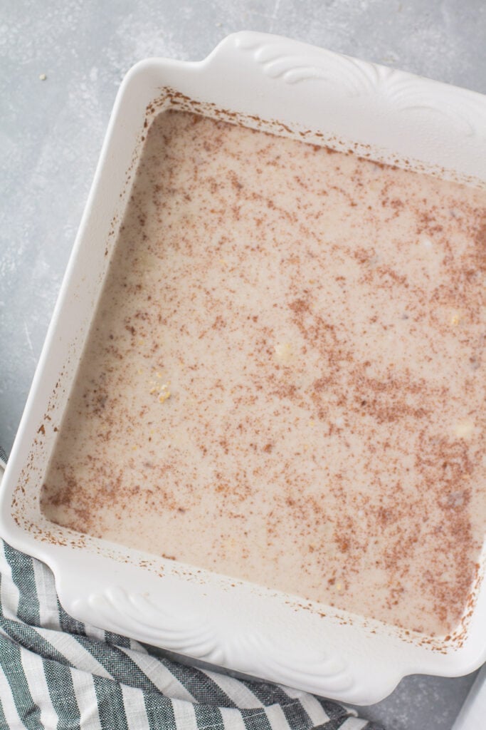 Steel cut oatmeal in a white baking dish on a grey background