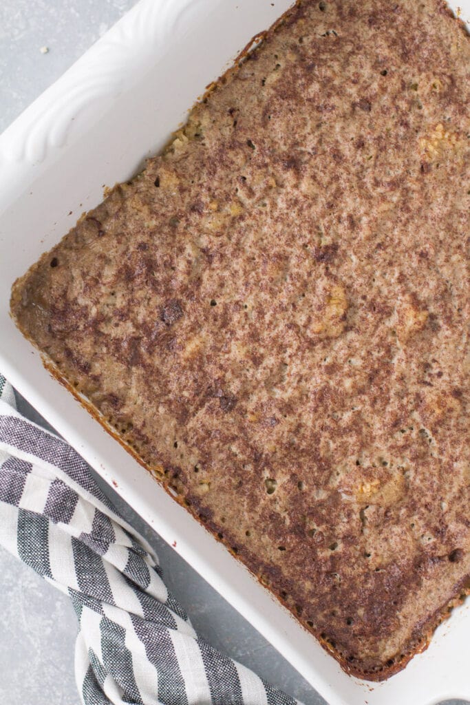 Baked steel cut oats in a white dish on a grey background