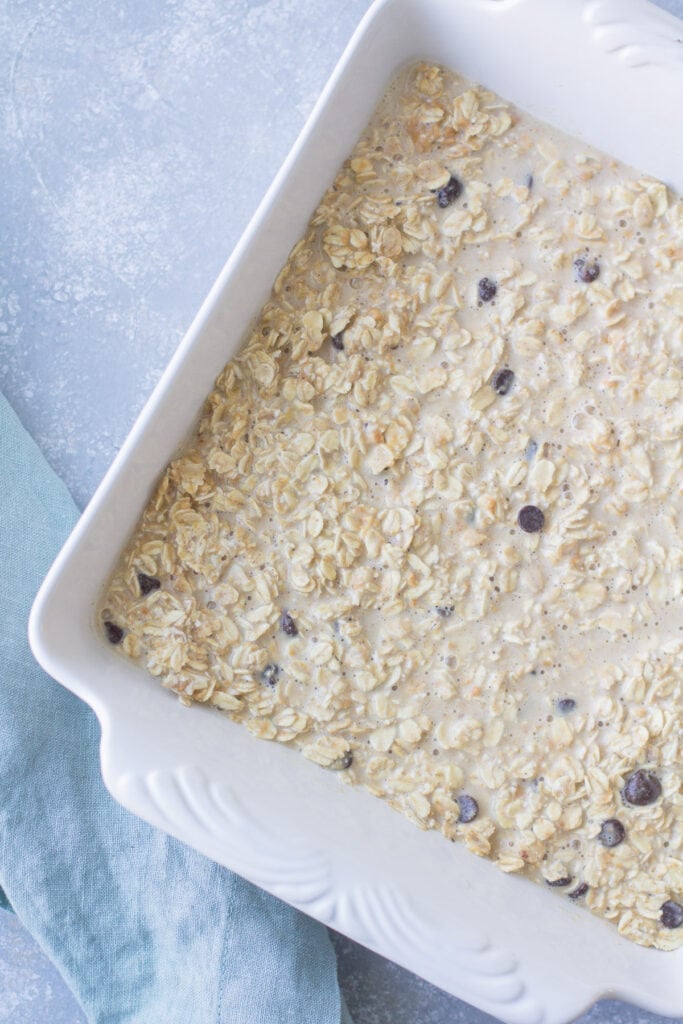 a white baking dish filled with chocolate peanut butter baked oatmeal before going in the oven