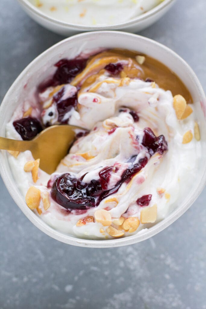 Peanut Butter & Jelly Yogurt bowl swirled together with a gold spoon