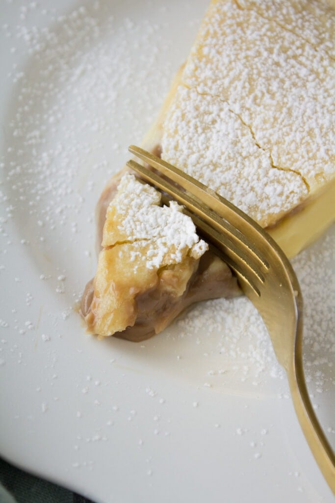 A fork taking a bite out of Italian Cream Pie on a white plate
